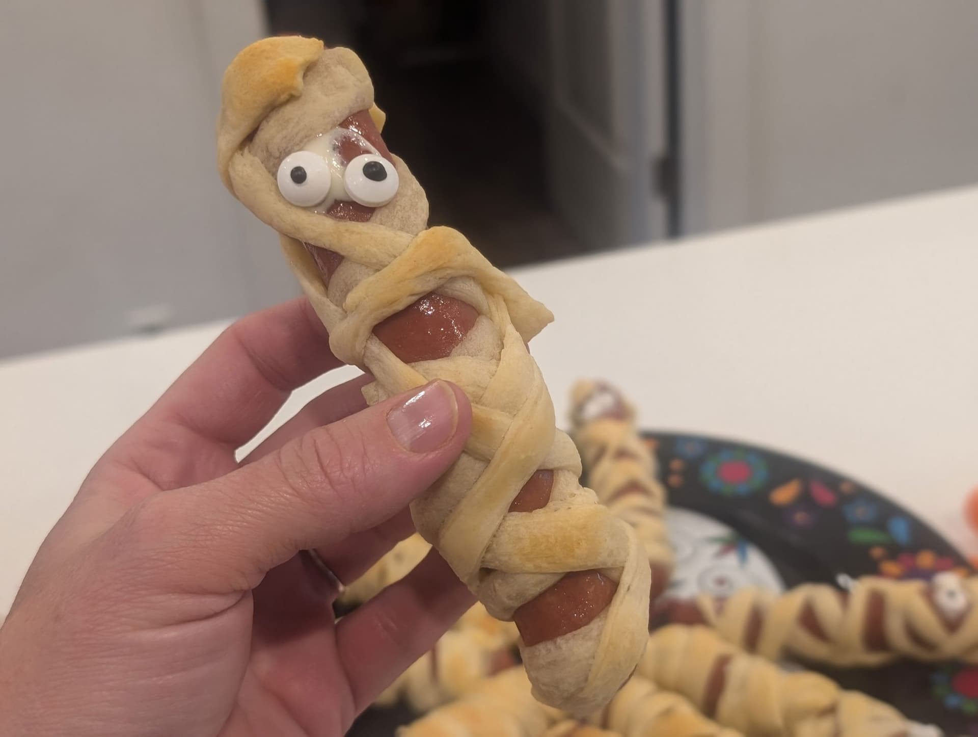 Halloween Mummy Dogs with Crescent Roll Wraps and Candy Eyes